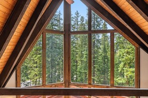A room with a large window offering a view of a forest. - The Rendezvous Chalet – Spacious Mountain Retreat (Breckenridge)