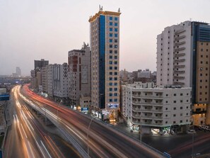 Um hotel com vários andares, entrada imponente e sinalização visível.