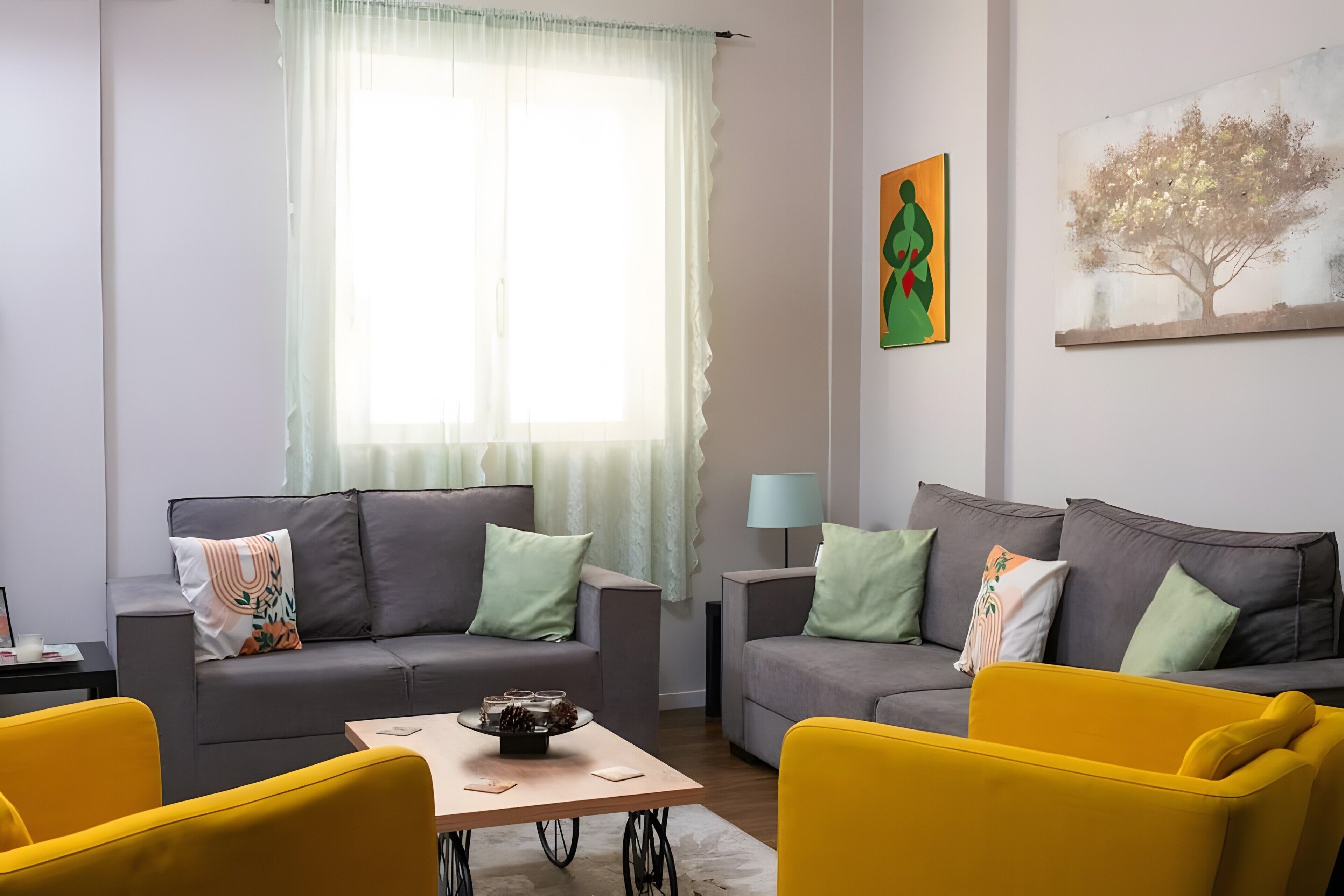 A modern living room with two sofas, a coffee table, and a yellow armchair.