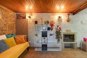 Ein gemütliches Wohnzimmer mit Steinwand, Holzboden und Kamin.