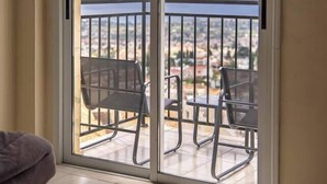 Une pièce dotée d’une porte-fenêtre coulissante donnant sur un balcon extérieur avec une rambarde en métal.