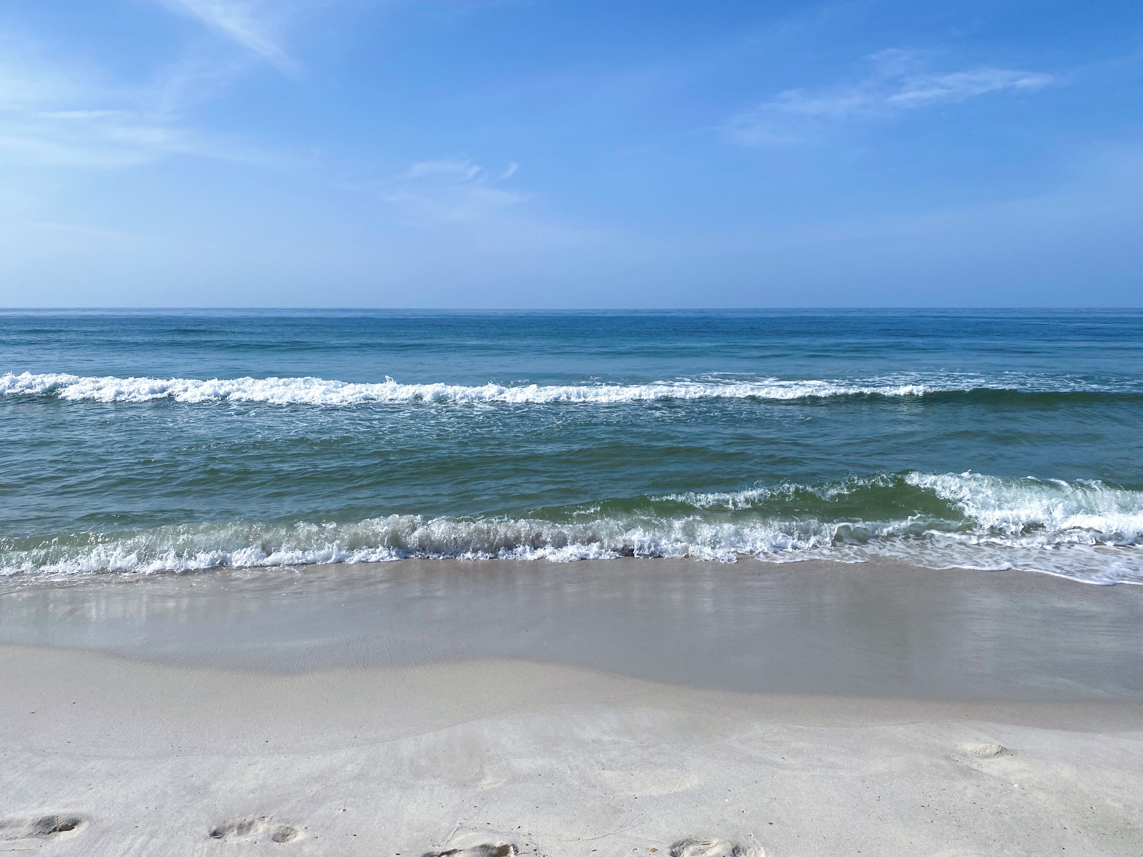 A beach with waves approaching the shore.