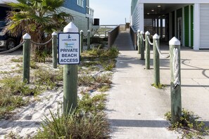A pathway leading to a private beach access area with a sign indicating restricted entry. - Lagoon Run 106 - Best of Both Worlds: Beach Access & Lagoon Dock! (Gulf Shores)