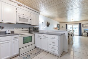 Eine Küche mit weißen Schränken, einer Mikrowelle, einem Toaster und einem Herd.