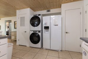 A laundry room with two stacked washers and a refrigerator. - Lagoon Run 106 - Best of Both Worlds: Beach Access & Lagoon Dock! (Gulf Shores)
