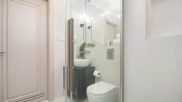 Ein modernes Badezimmer mit Duschkabine aus Glas, einer weißen Toilette und einem Waschtisch.
