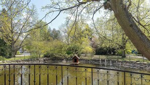 A park with a pond, a wooden deck, and a metal fence. - Stylish Apartments with Balconies | Panoramic Terrace | Close to the Brine Graduation Towers (Ciechocinek)