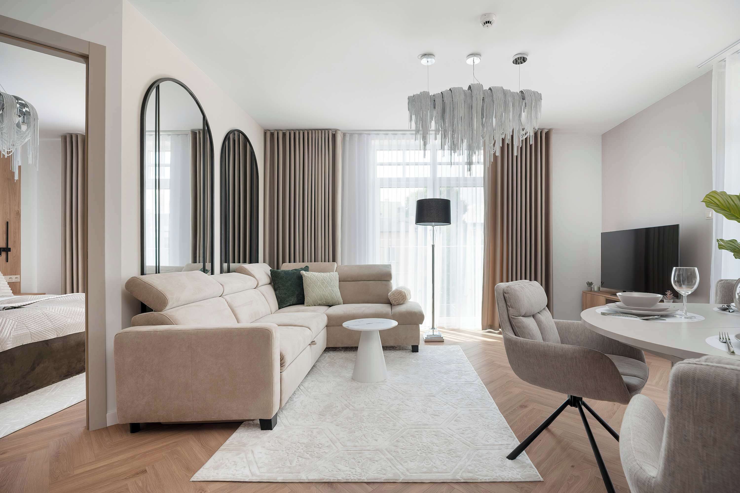 Een moderne woonkamer met een bank, salontafel en een eethoek.