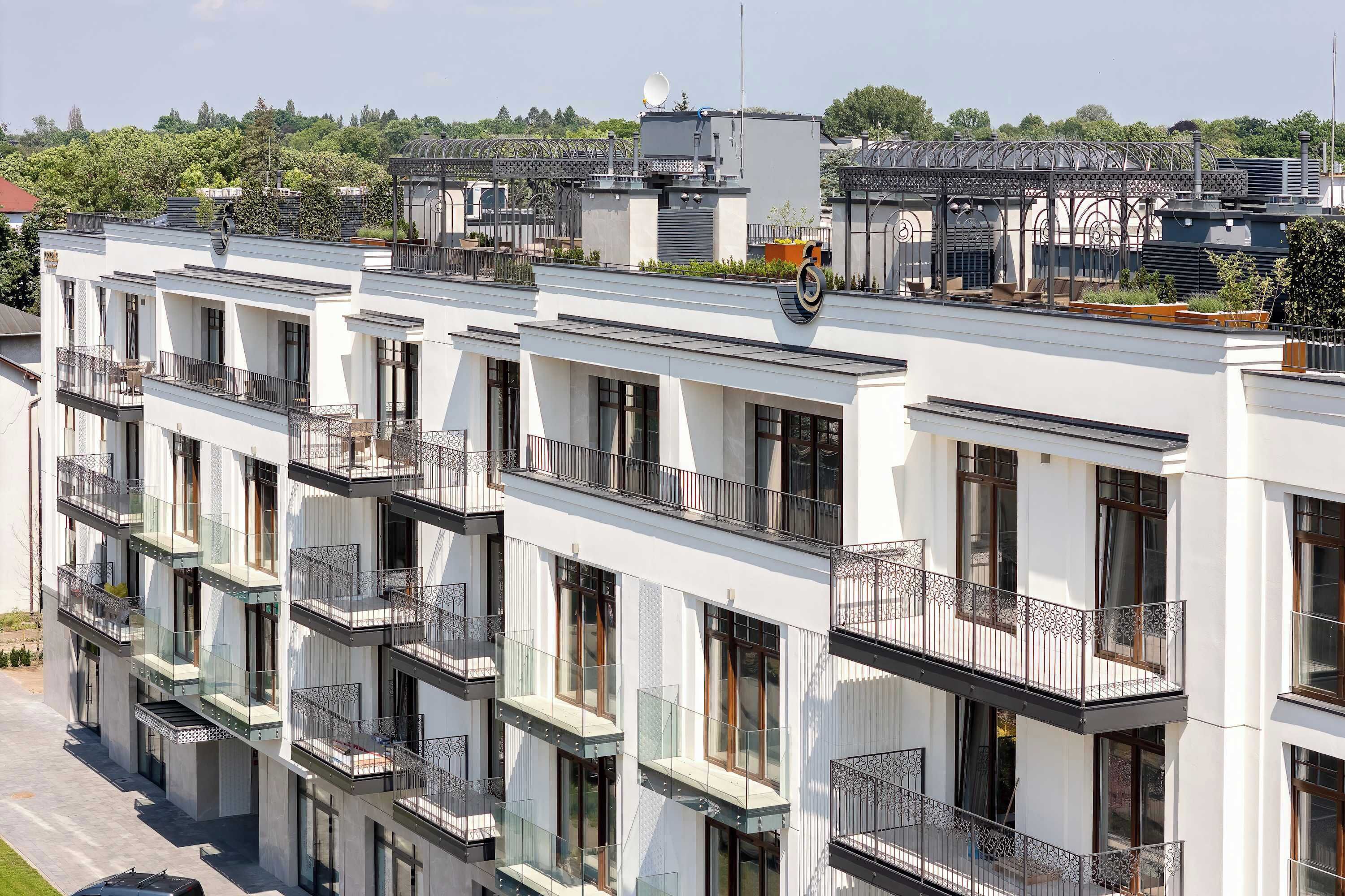 Un edificio residencial de varios pisos con balcones, ventanas amplias y techo plano.
