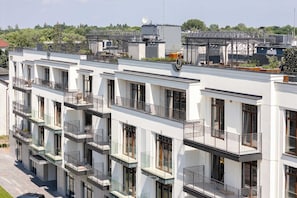 A multi-story residential building with balconies, large windows, and a flat roof.