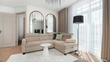 Een moderne woonkamer met een beige modulaire bank, een witte salontafel en een vloerlamp.