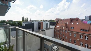 Un immeuble de grande hauteur doté d’un balcon en verre offrant une vue sur le paysage urbain.