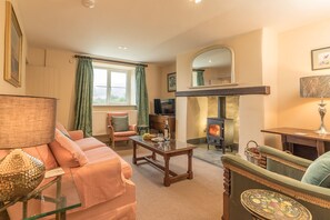 A cozy living room with a fireplace, comfortable seating, and a television. - Gorgeous Stone Cottage At the Foot Of The Berwyn Mountains | Ceseilgwm (Corwen)