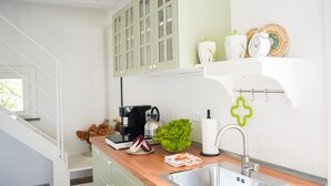 Eine moderne Küche mit Holzarbeitsplatte, Edelstahlspüle und einer Kaffeemaschine.