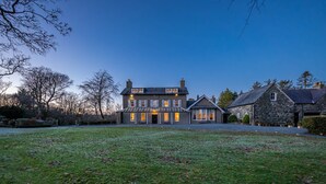 A large, two-story stone house with a well-maintained lawn in front. - Georgian Country House and Stable Sleeping 18 | Gorwel-Bryn-Hir (Criccieth)