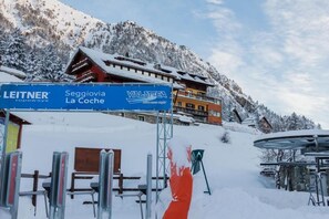 A snow-covered mountain with a building and a sign for 'Leitner Ropeways' and 'Seggiovia La Coche.' - Hotel Al Foiron (Claviere)