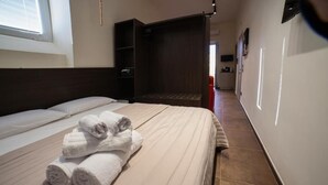 A hotel room with a bed, a wardrobe, and a bathroom visible through an open door. - Sciuscià beb spaccanapoli (Naples)