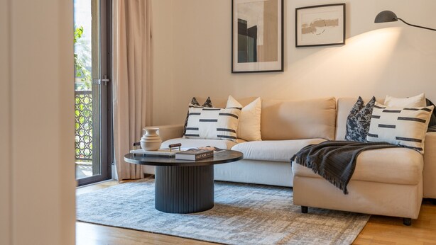 Ein zeitgemäßes Wohnzimmer mit Sofa, Couchtisch und Bücherregal.