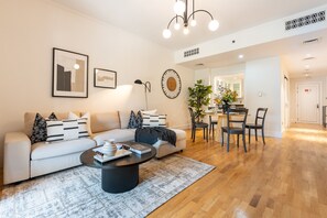Een moderne woonkamer met een bank, salontafel en eethoek.