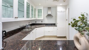 Eine moderne Küche mit weißen Schränken, einer Granitarbeitsplatte und einer Edelstahl-Dunstabzugshaube.