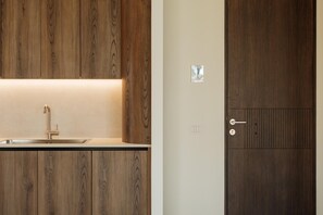 Uma casa de banho moderna com toucador de madeira, uma pia e uma porta com fechadura.
