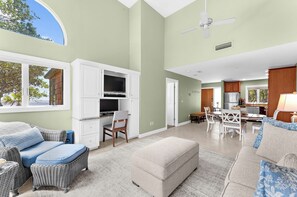 A spacious living area with a dining table, kitchen, and seating arrangements.