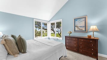 Une chambre à coucher avec un lit, une commode, une lampe et un tableau.