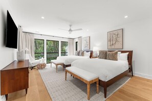 A modern bedroom with a large bed, two bedside tables, a desk, and a chair. - Charming new Ocean Park home (Kiawah Island)