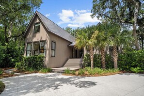 A modern two-story house with a sloped roof, large windows, and a front porch. - 333 Victory Bay : 4  BR, 4.5  BA House in Kiawah Island , Sleeps 10 (Kiawah Island)