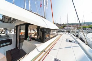 Uno yacht con una zona di copertura, posti a sedere e un oblò che si affaccia sul porto turistico.