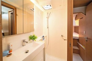 A compact bathroom with a shower, a sink, and a mirror. - Excess 11 - First Sight (Skradin)