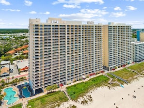 A high-rise hotel with multiple balconies, a pool area, and a beach access. - Beachfront Bliss with Gulf Views and Resort Pools (Panama City Beach)