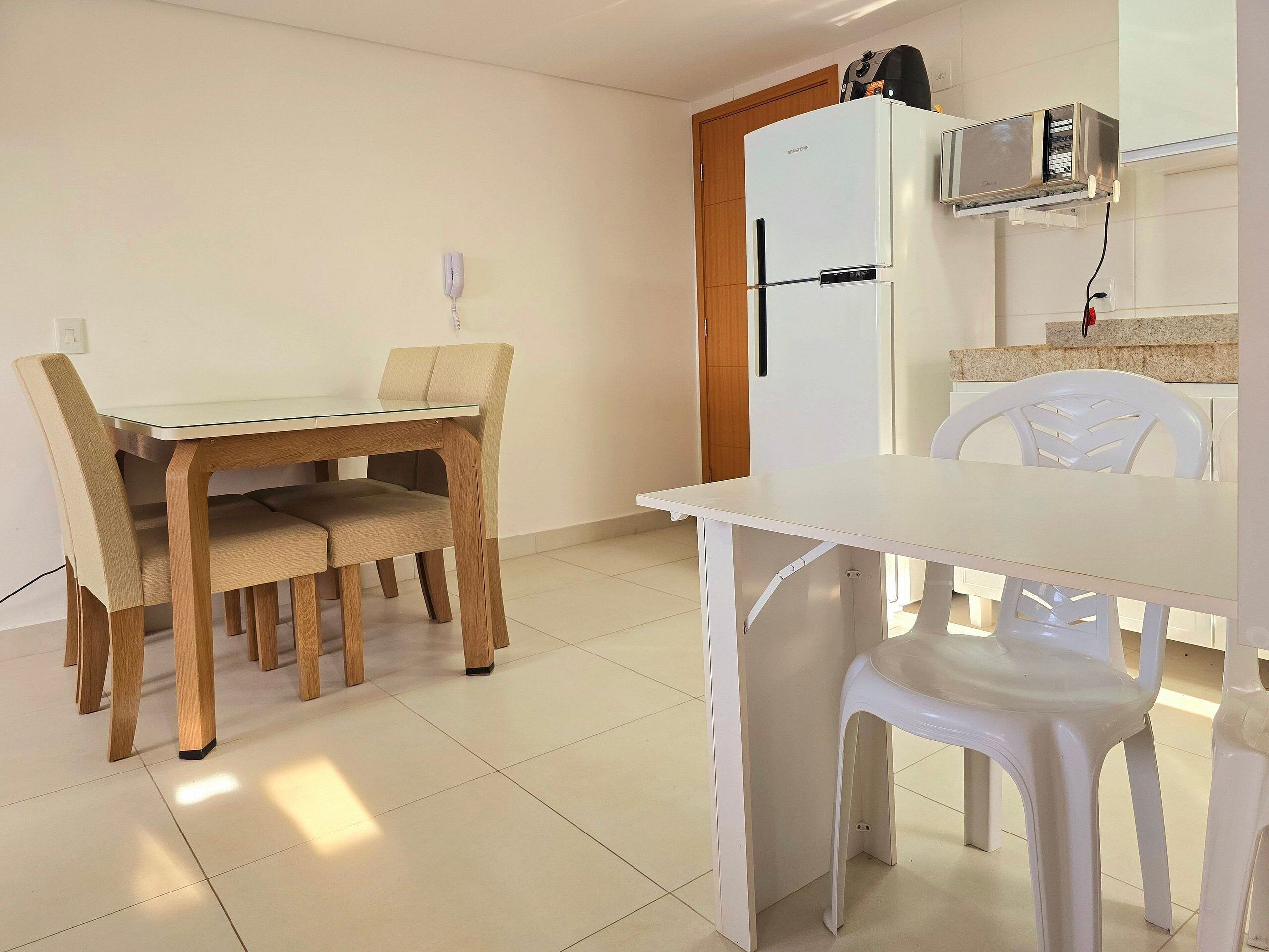 A compact kitchen with a white refrigerator, a microwave, and a small countertop.