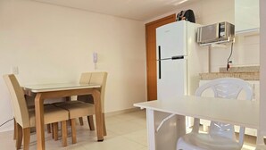 Una cocina compacta con un refrigerador blanco, un microondas y una pequeña encimera.