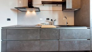 Una cucina moderna con piano cottura integrato, lavello e un bancone in legno.