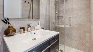 A modern bathroom with a large white sink, a glass shower enclosure, and a mirror above the sink. - B2G. 6 people—Champs-Élysées—Wagram—Arc de Triomphe—AC (Paris)