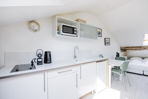 A modern kitchen with a microwave, coffee maker, and sink. - Palais Royal – Louvre Museum – Central Studio (Paris)