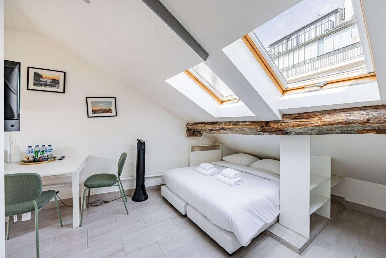 Ein Zimmer mit einem Etagenbett, einem Schreibtisch mit Stuhl, einer Gitarre und einem Dachfenster.
