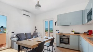Eine moderne Küche mit Backofen und einer Essecke mit Tisch und Stühlen.