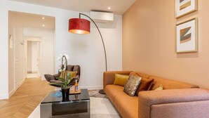 Un salon moderne avec un canapé, une table basse et une suspension rouge.