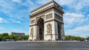 A large stone monument with intricate carvings and two large arches, surrounded by a crowd of people. - B1G. 4 people—Champs-Élysées—Wagram—Arc de Triomphe—AC (Paris)