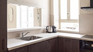 Una cocina moderna con armarios de madera oscura, un lavamanos de acero inoxidable y una ventana que proporciona luz natural.