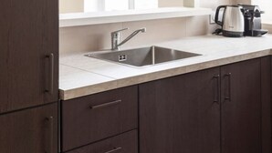 Una cocina moderna con un lavamanos integrado, muebles oscuros y una ventana sobre la encimera.