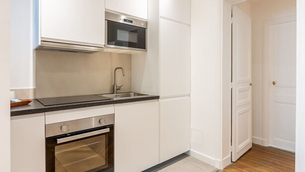 A compact kitchen with a microwave, oven, and sink. - B2D-2 people-Wagram-1 bedroom-Ternes-AC (Paris)