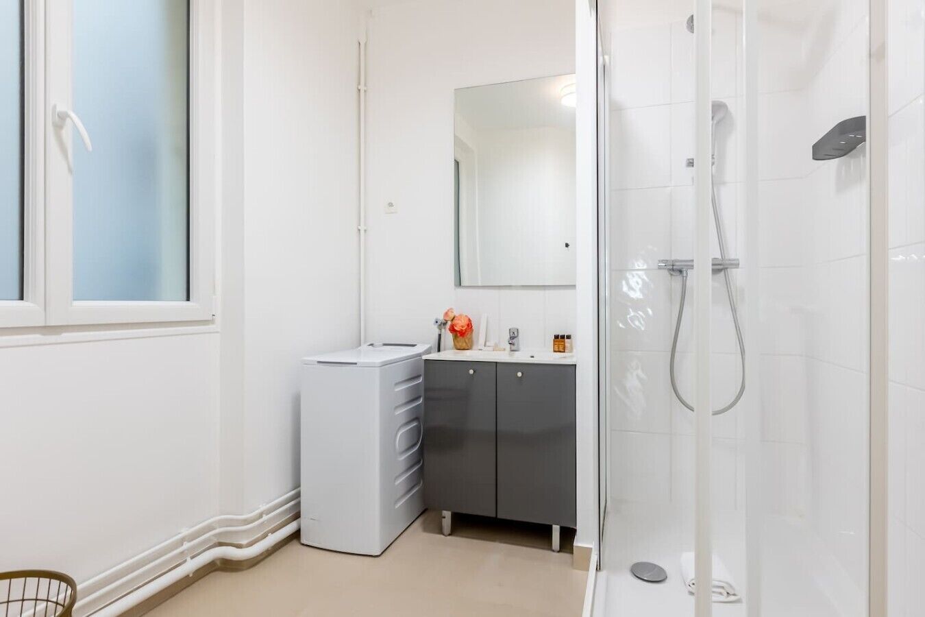 A bathroom with a shower, a sink, and a cabinet.