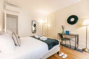 Ein Hotelzimmer mit einem Bett, einem Schreibtisch, einem Stuhl, einem Spiegel und einer Lampe.