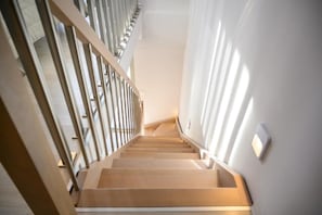 A staircase with wooden steps and metal railings, leading upwards. - SARTI PREMIUM LUXURY SUITES (SITHONIA)