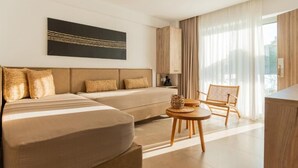 A modern hotel room with a large bed, a sofa, a dining table, and a chair. - SARTI PREMIUM LUXURY SUITES  (SITHONIA)