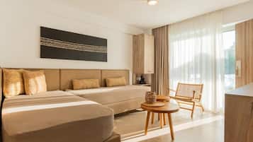 A modern hotel room with a large bed, a sofa, a dining table, and a chair.