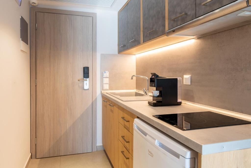 Una cocina moderna con lavavajillas incorporado, cafetera y armarios de madera.